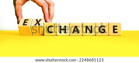 Change or exchange symbol. Businessman turns wooden cubes and changes the word change to exchange. Beautiful yellow table, white background, copy space. Business and change or exchange concept.