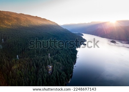 Aerial drone photo of sunrise over mountains and ocean shot of Quarry Rock with hikers on-top in Deep Cove, North Vancouver.