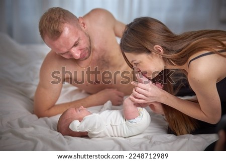 Happy young parents spend time with their little child. The concept of family and love. Family morning at home.