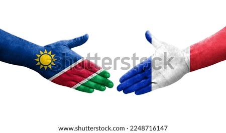 Handshake between France and Namibia flags painted on hands, isolated transparent image.