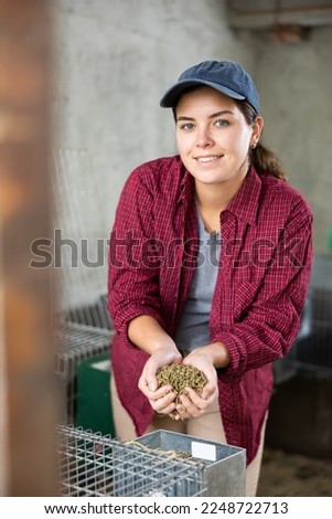 Female worker showing feed for animal in her hands