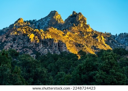 A snowy peak in the Hualapai Mountain range in Arizona catches the last rays of the setting sun. Royalty-Free Stock Photo #2248724423