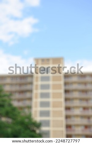 Defocused view of tall building in Cite Rotterdam, the first large complex built in France after the Second World War with pedestrians and parked cars - typical French neighborhood
