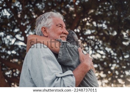 Head shot close up portrait happy grey haired middle aged woman snuggling to smiling older husband, enjoying tender moment at park. Bonding loving old family couple embracing, feeling happiness. Royalty-Free Stock Photo #2248737011