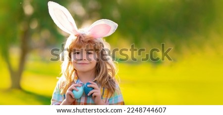 Bunny child boy face. Child boy hunting easter eggs. Child boy with easter eggs and bunny ears in park. Horizontal photo banner for website header design with copy space.