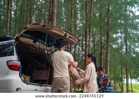 Group of Asian people friends enjoy outdoor lifestyle road trip and camping together on summer holiday travel vacation. Man and woman taking off camping supplies from car trunk at natural park. Royalty-Free Stock Photo #2248745129
