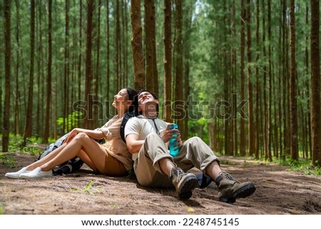 Happy Asian family couple travel on summer holiday vacation trip. Man and woman traveler enjoy outdoor active lifestyle hiking and resting together in pine tree forest mountain. Royalty-Free Stock Photo #2248745145