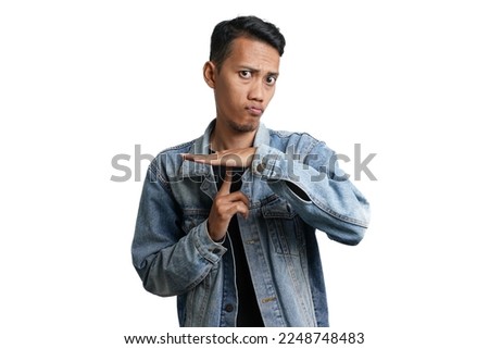 Asian man wearing blue jean jacket gesturing silence, don't make noise. Isolated by white background