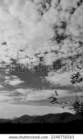 black-white picture vertically, dark sky white cloud above top view high mountain, landscape background around countryside. Thailland