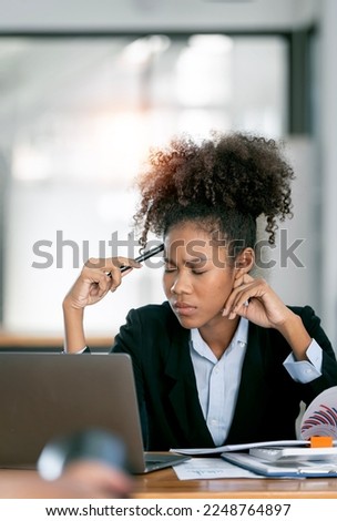 Frustrated young african american woman keeping eyes closed after working at laptop for long time in office, feeling tired and stressed. Royalty-Free Stock Photo #2248764897