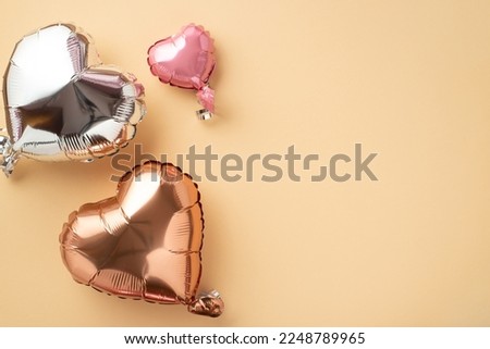St Valentine's Day concept. Top view photo of flying heart shaped balloons on isolated pastel beige background with blank space
