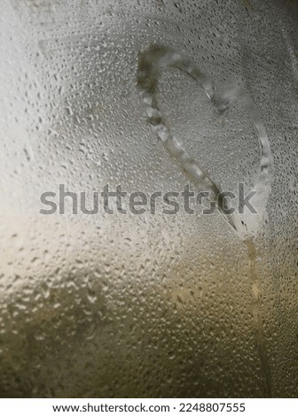 A love sign is painted on the fogged glass