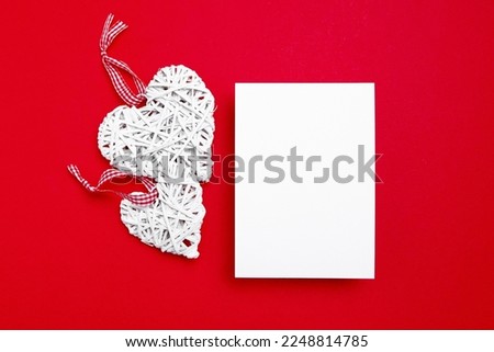 Valentine Day card mockup with white hearts on red background, top view, flat lay. Blank wedding invitation, flyer, greeting card mockup with holiday decor. Empty love letter with copy space