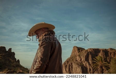 Adult man in cowboy hat against mountain and sky. Almeria, Spain