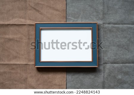 Picture frame on brown and gray fabric background. top view, copy space