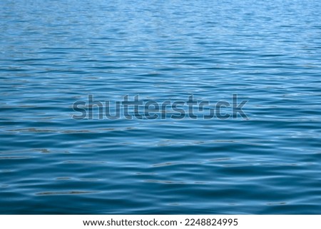 Beautiful blue water ripples on waves of the surface of a lake in Bhandardara in Maharashtra, India
