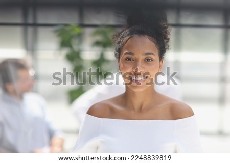 a business woman smiling inside office building