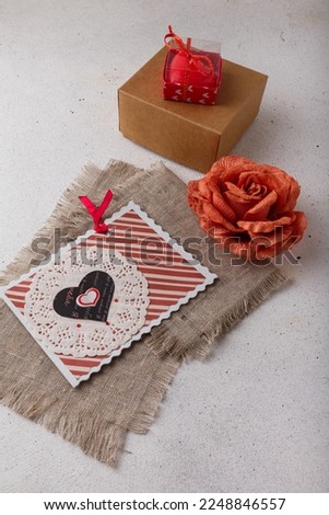 Present box, fabric rose flower, postcard, sackcloth and heart-shaped red candle on white background. Valentines day, birthday, wedding. Inscription reads I LOVE YOU