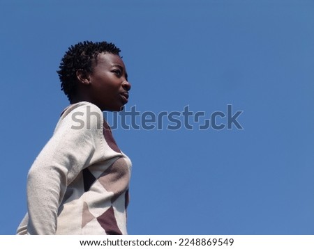 young african girl with braids against the blue sky Royalty-Free Stock Photo #2248869549