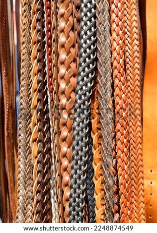 Many braided leather belts at a flea market, popular menswear 