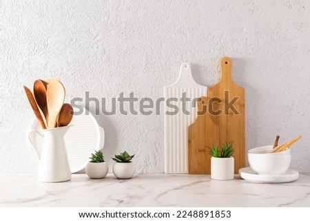 various kitchen utensils on a white marble countertop in a modern kitchen. the concept of decor against the background of a textured gray wall Royalty-Free Stock Photo #2248891853