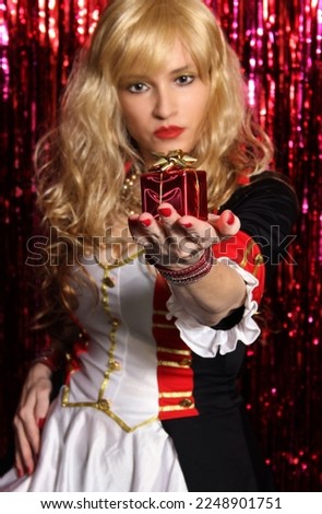 Blonde Woman Wearing Toy Soldier Costume and Holding Christmas Gift in Hand