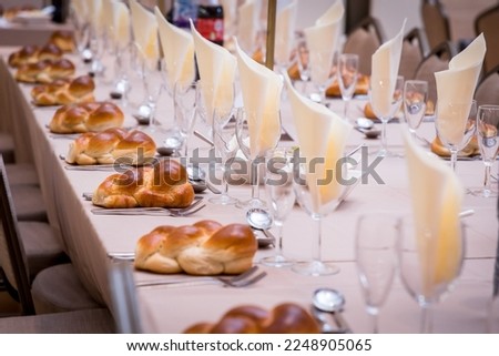 Wedding, bar mitzvah Orthodox Jewish wedding event challah-bread with knife as per Hasidic tradition. Set on dining place setting. Shabbat meal Royalty-Free Stock Photo #2248905065