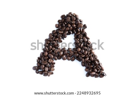 Coffee beans in the shape of isolated on a white background.Heart made of coffee beans on black concrete background.