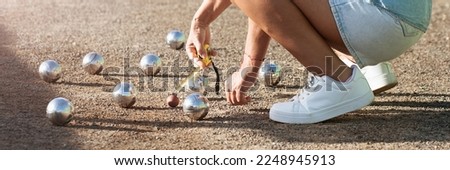 Petanque game, woman measuring the distance of petanque ball in petanque field, deciding who's the winner Royalty-Free Stock Photo #2248945913