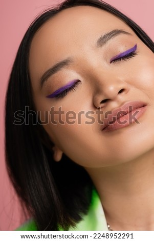 close up view of young asian woman with perfect makeup with blue eyeliner isolated on pink Royalty-Free Stock Photo #2248952291