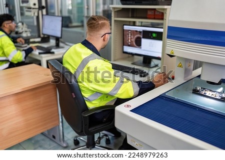Engineer sitting in robot fabrication room use measuring microscope machine check electronic board