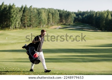 a golfer walks along a green field with a bag in which clubs. Caddy carries clubs. High quality photo