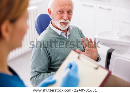 Senior man having checkup at doctor's office, consulting about necessary procedures,  general practitioner taking medical records Royalty-Free Stock Photo #2248981651