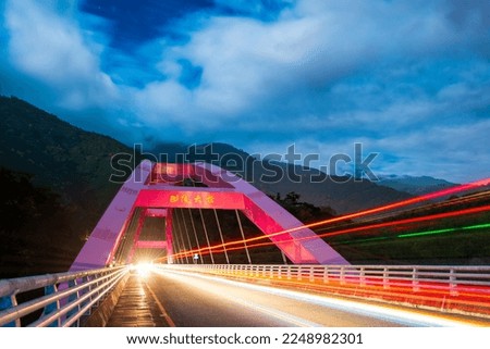 Fast moving white clouds. Slow photography of headlights on red bridge. Baling Bridge is located on the Beiheng Highway. Taoyuan City, Taiwan. Translation: "The name of the bridge is Baling Bridge" By