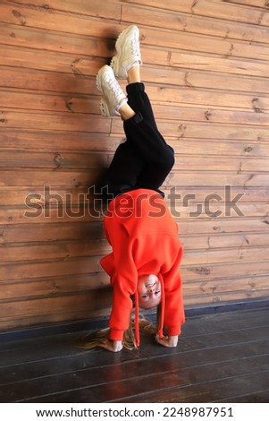 Girl performs gymnastic exercise. Young gymnast girl stretching and training. 
