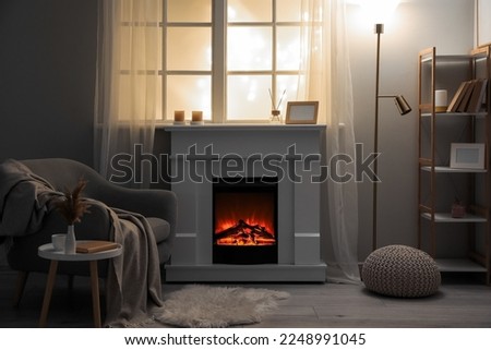 Interior of modern living room with electric fireplace and armchair