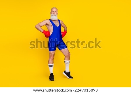 Full length photo of serious confident retired man dressed blue overall costume practicing boxing empty space isolated yellow color background