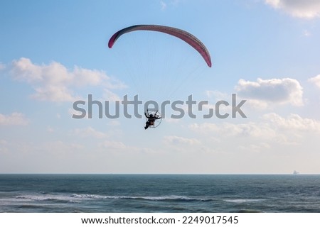 Parachutist flying over sea on summer day Royalty-Free Stock Photo #2249017545