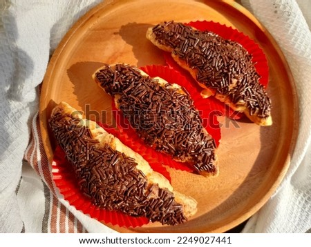 Sprinkled chocolate on a sweet croissant and looks attractive on a wooden plate