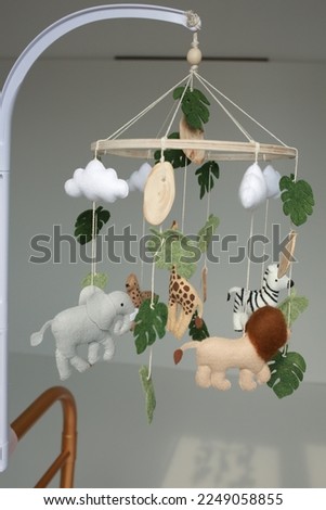 children's mobile for a bed in the style of animals lion, giraffe, zebra. decor for a children's bed