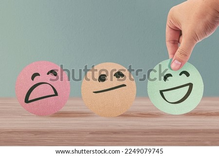 Hand choosing green happy smile face paper cut, feedback rating and positive customer review, experience, satisfaction survey, mental health assessment, world mental health day, think positive concept