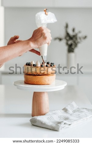 Pastry chef decorating cake. White Kitchen. aesthetic picture
