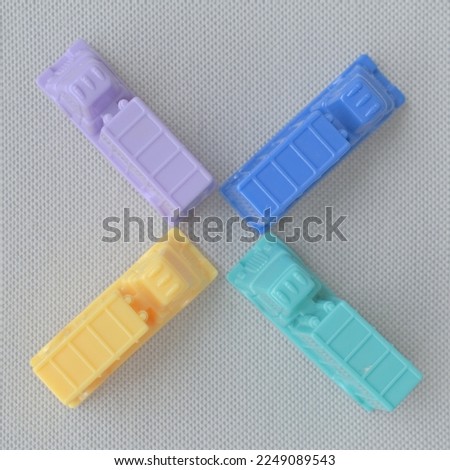 Horizontal framing of the letter X or the multiplication sign. This photography is a part of a conceptual image serial illustrating a sign or a letter using toy pastel colored plastic cars and trucks.