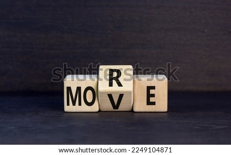 More move symbol. Concept word More move on wooden cubes. Beautiful black table black background. Business and more move concept. Copy space.