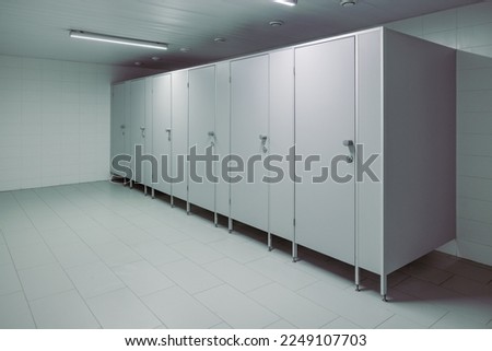 Public toilet cubicles. Clean toilet, view from inside the room. Closed cubicle doors in a public restroom Royalty-Free Stock Photo #2249107703