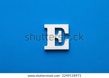 Letter E uppercase - White wood font on blue foamy background