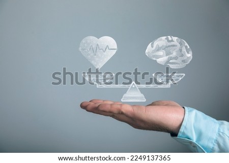 On the scales the brains and heart from the network. Man holding in his hand