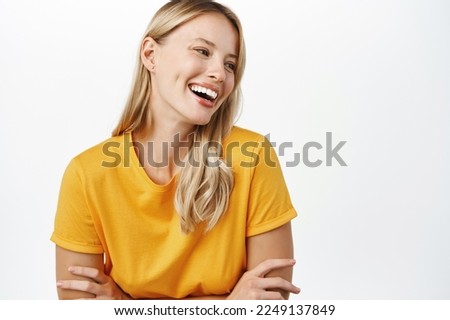 Portrit of beautiful modern woman with natural blond hair, white smile, clear perfect skin, laughing and smiling, standing in yellow t-shirt over white background