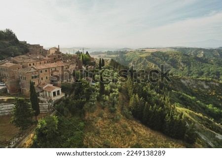 Small village of Chiusure on top of the hill surrounded by Karst cliffs landscape photographed with a drone. Toscana, Tuscany, Asciano, province of Siena in Italy with a little mud road 06.16.2021 Royalty-Free Stock Photo #2249138289
