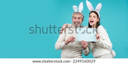 Happy easter for your company. Bunny: upset rabbit couple. Portrait of happy Easter bunny man and woman hold board paper for text. Horizontal photo banner for website header design.